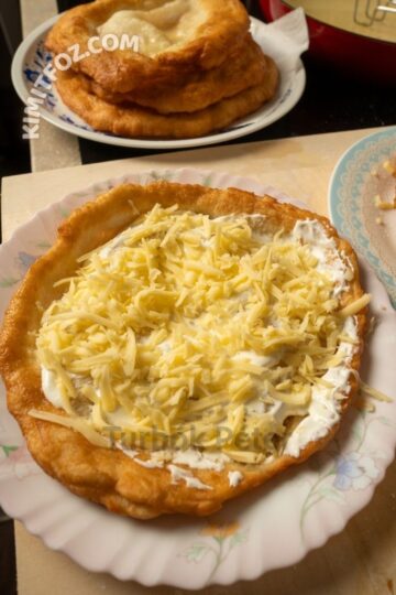 Piaci lángos házilag, tejföllel és reszelt sajttal tálalva